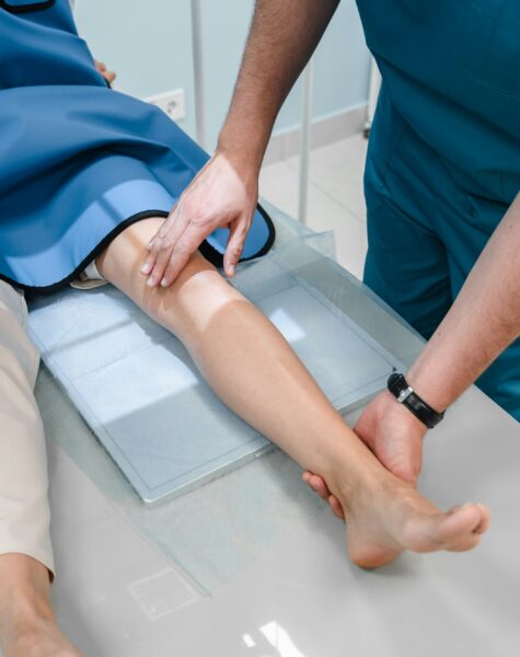 A doctor in X-ray room radiologist sets up a machine for radiography of a patient and makes a scan.