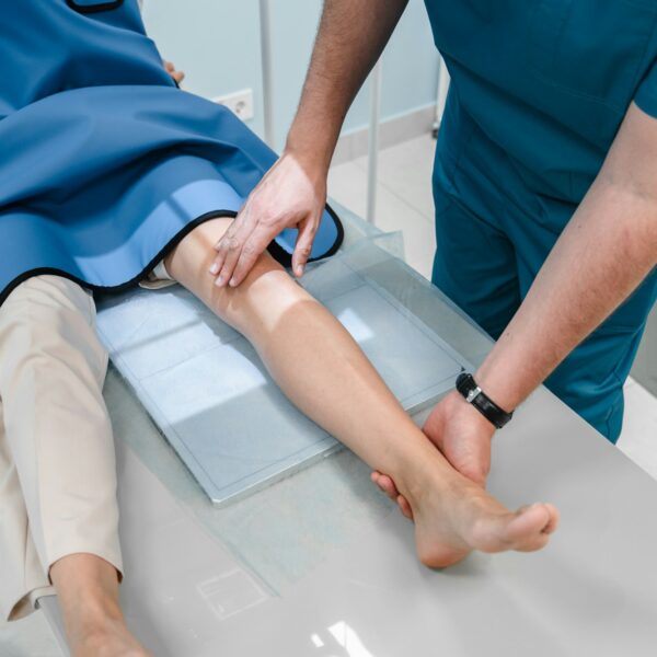 A doctor in X-ray room radiologist sets up a machine for radiography of a patient and makes a scan.