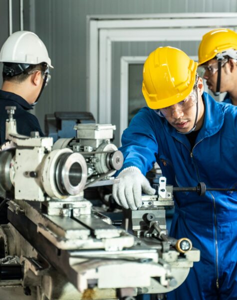 Asian mechanical technicians workers working on operating milling machine for safety precaution.