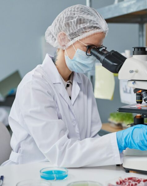 Chemist using microscope at work