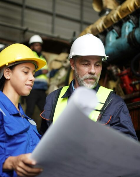 Portrait of engineer and apprentice in workshop of railway engineering facility