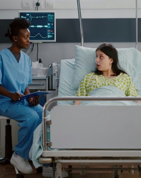 Sick woman adult resting in bed while black nurse analyzing disease expertise