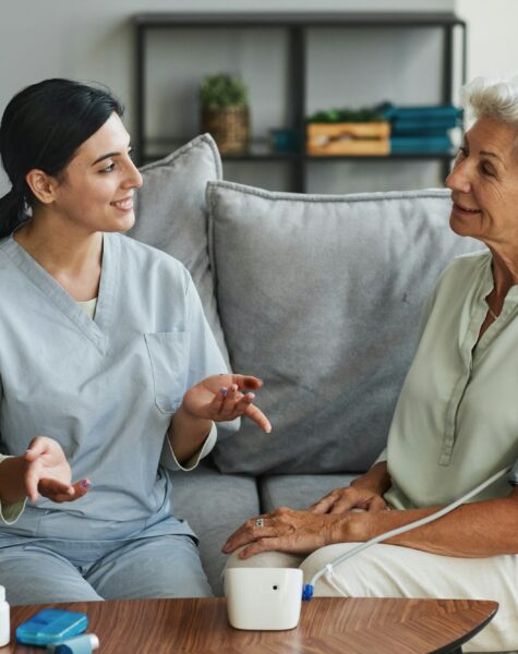 Young Nurse Talking to Senior Woman in Retirement Home