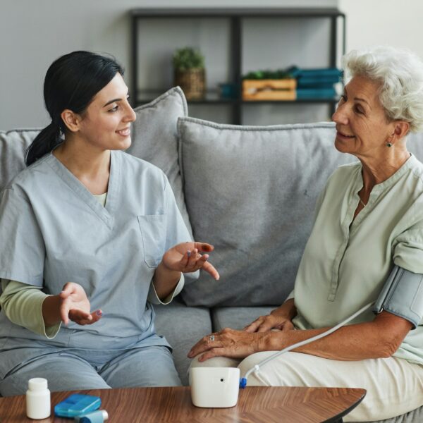 Young Nurse Talking to Senior Woman in Retirement Home